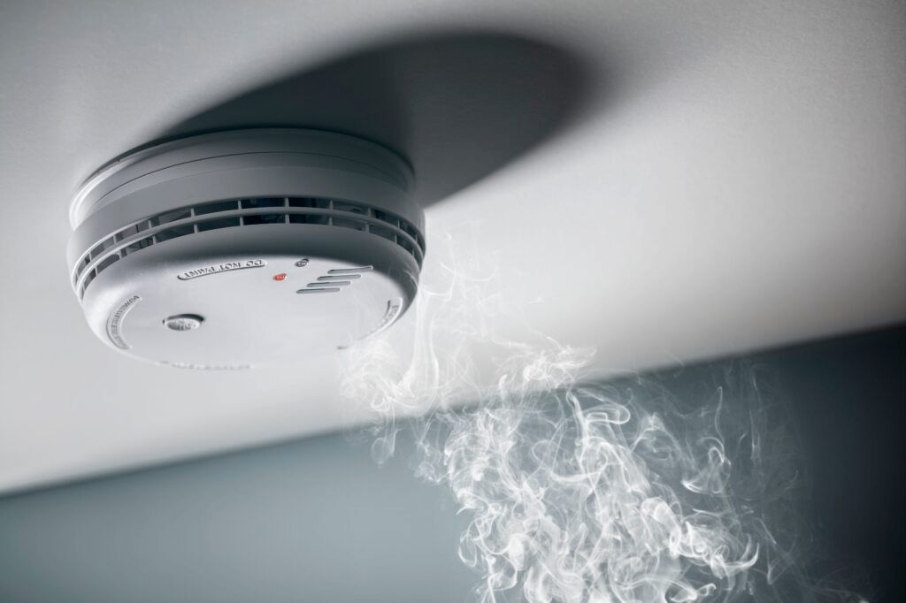 Smoke Detector on a Ceiling Emitting Smoke — FNQ Smoke Alarms & Maintenance in Atherton, QLD