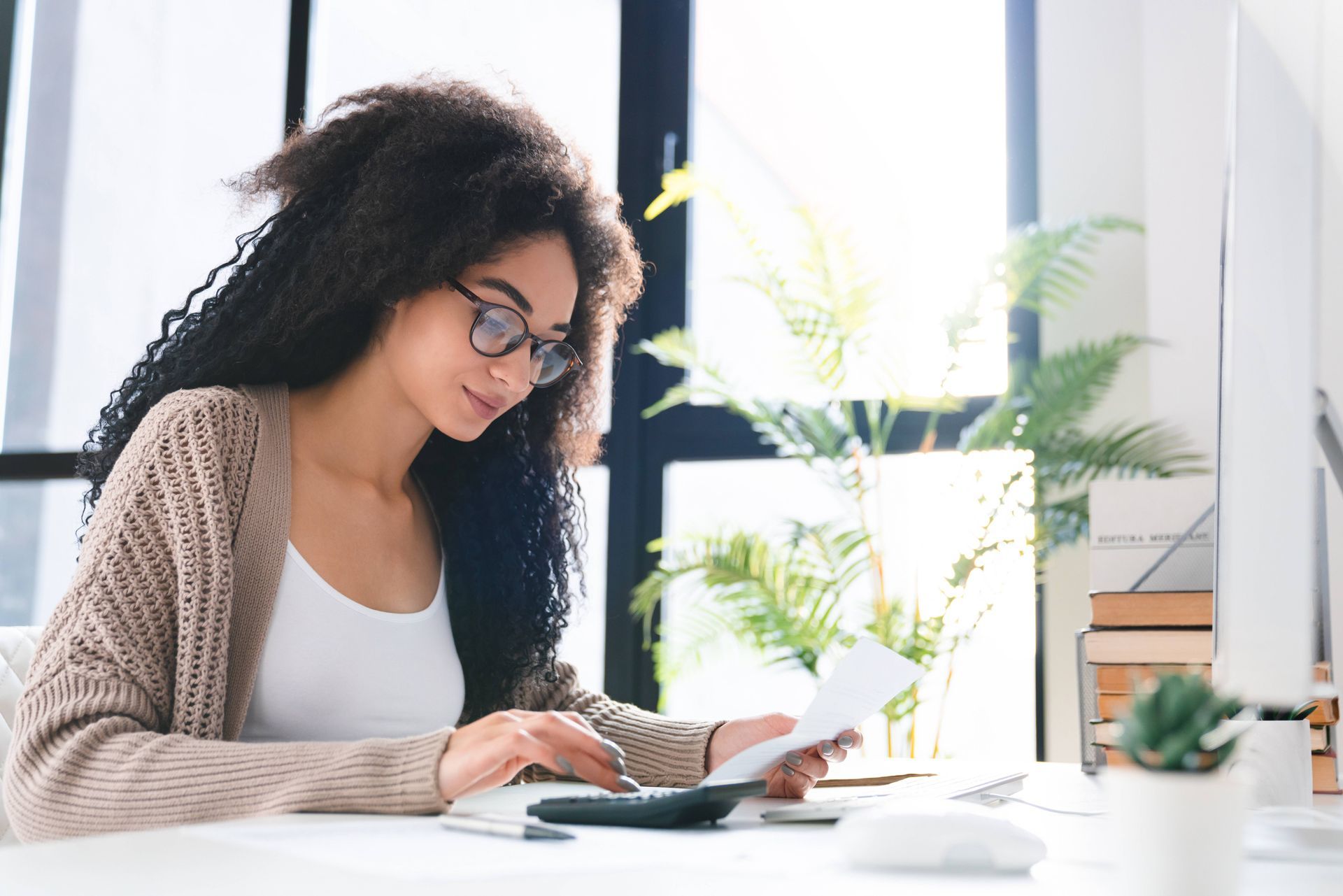 A young woman with a calculator studying utilities bill