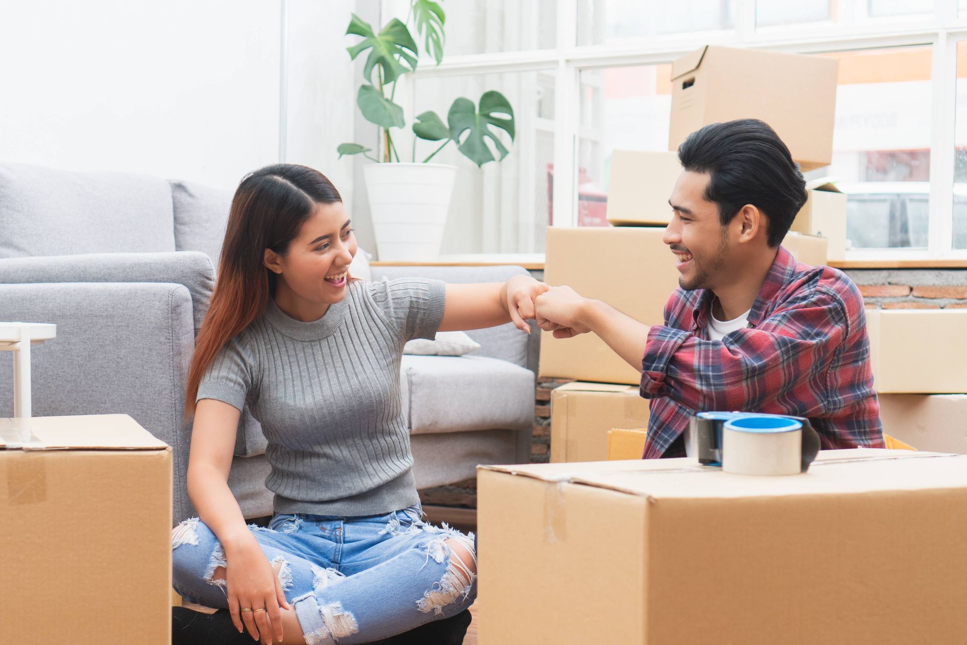 Happy couple sitting with boxes after moving in to new apartment for rent near Richmond, Kentucky