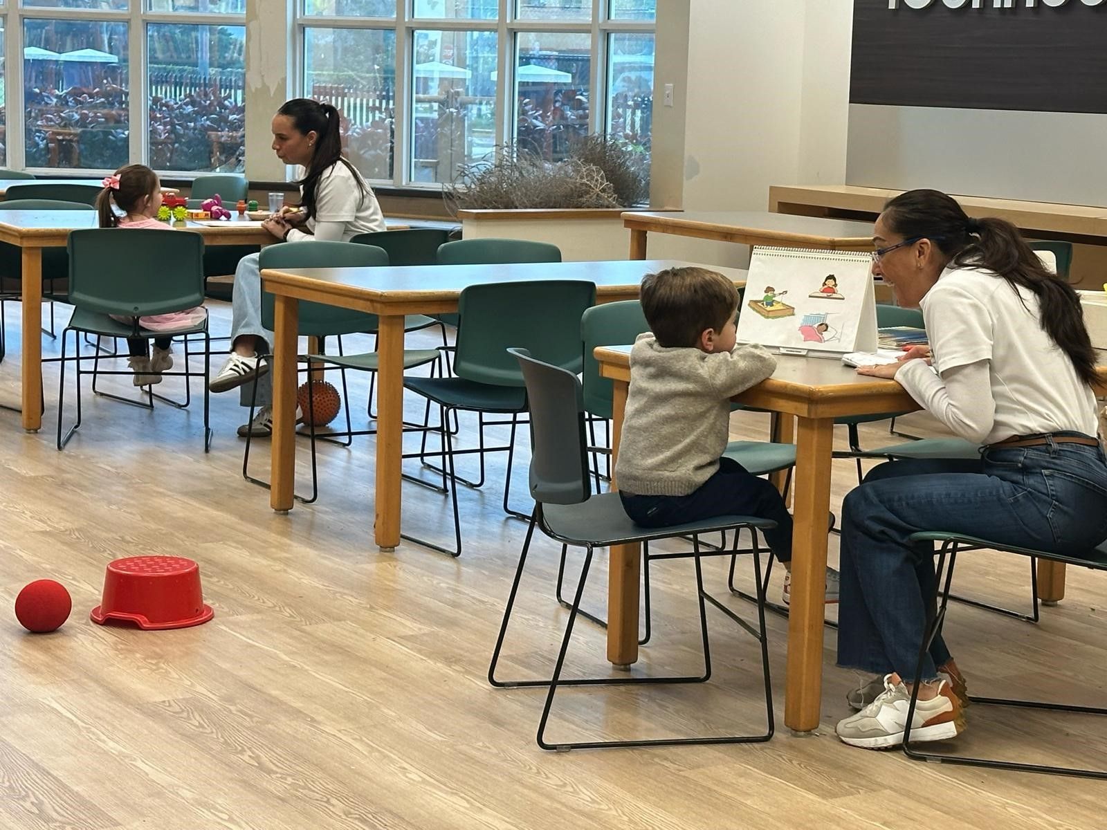 A woman is sitting on the floor with a child playing with toys. A woman is sitting on the floor with a child playing with toys.