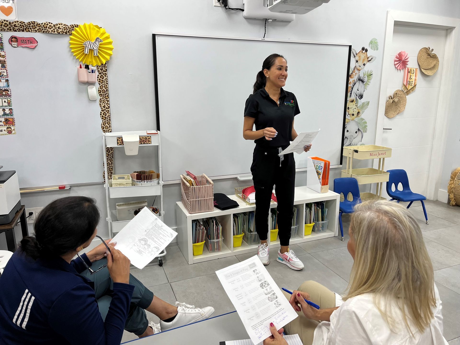 Two women are talking to a young boy in a room. Two women are talking to a young boy in a room.