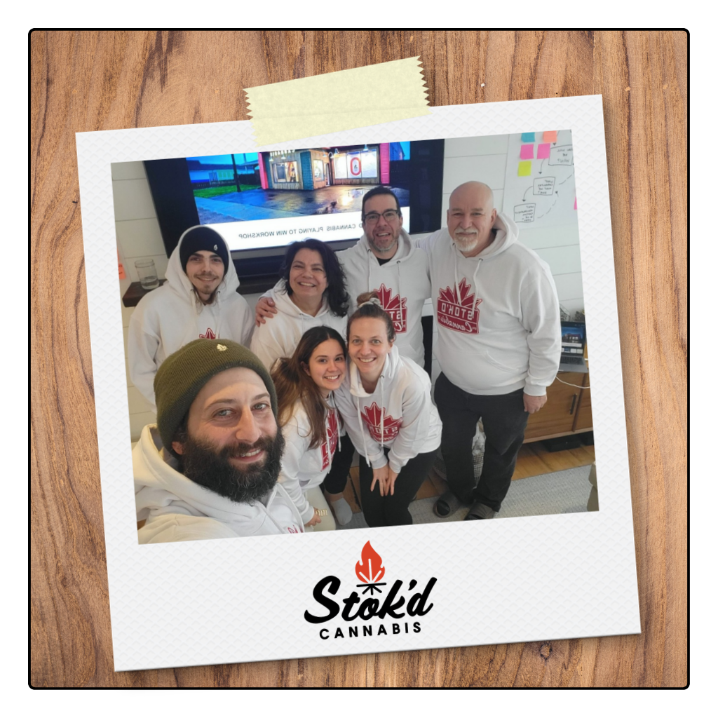 Six coworkers smiling for a group selfie at Stk’d Cannery, with logo visible below.