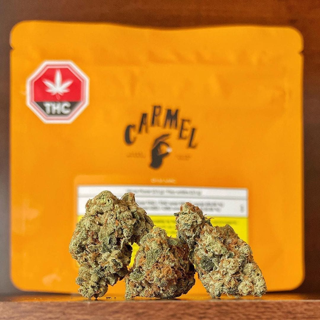 Orange THC cannabis package with three marijuana buds in front