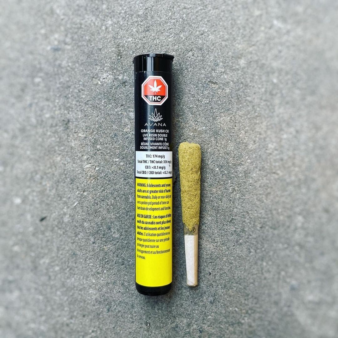 A black-and-yellow tube standing beside a small cylindrical abrasive tool on a gray surface.