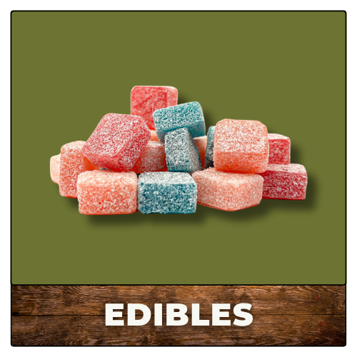 Assorted red, blue, and pink sugar-coated gummy edibles stacked on a green background.