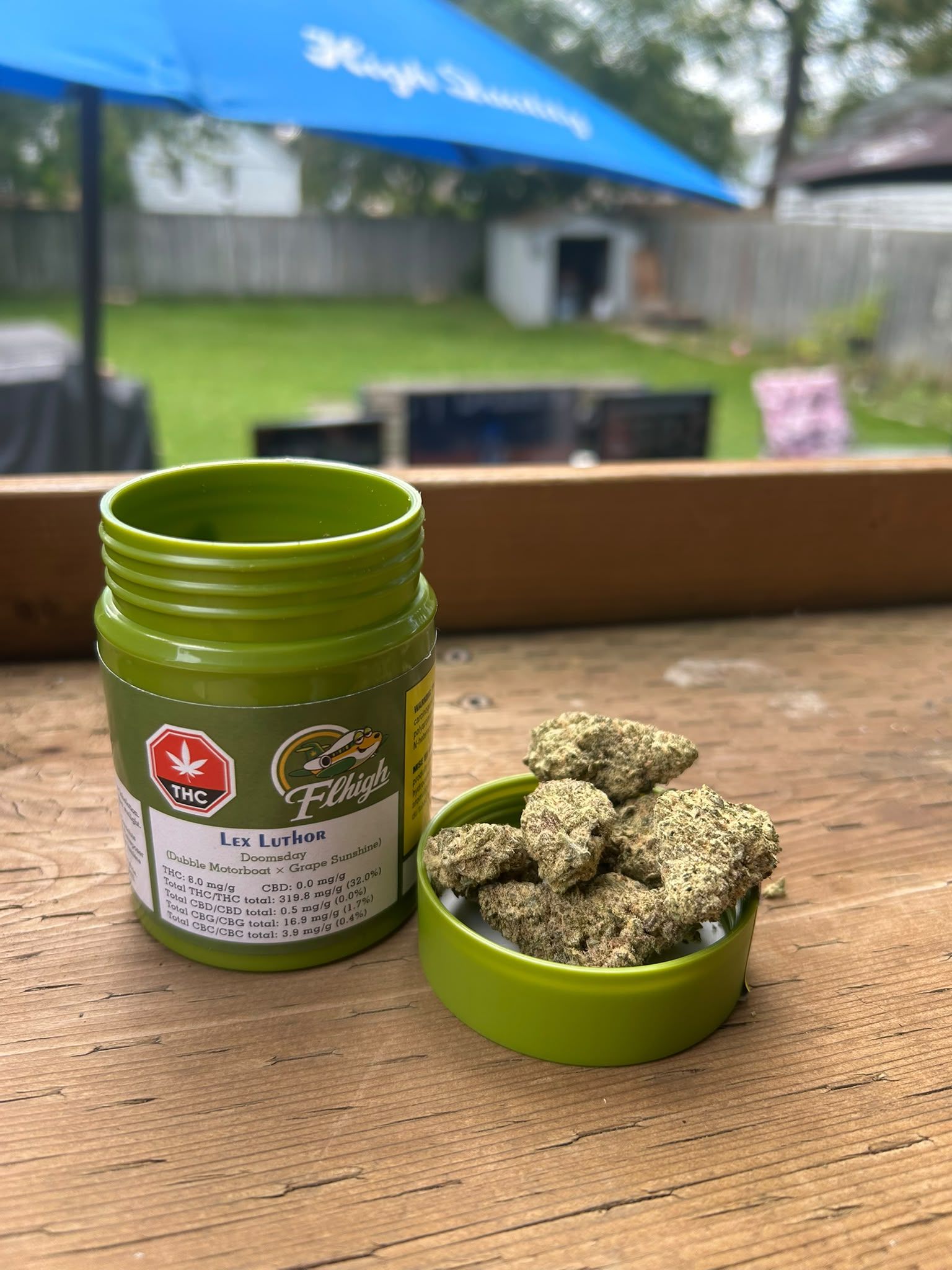 Flhigh Lex Luthor jar beside frosty cannabis buds in its lid