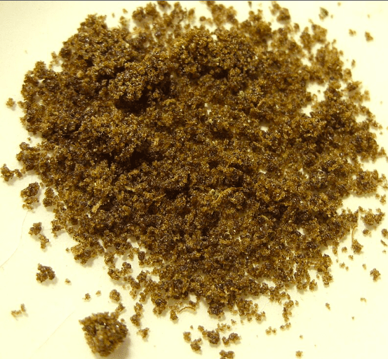 Pile of brown granular powder on a light background