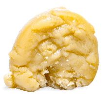 A close-up of a yellow, crumbly frozen dessert scoop on a white background