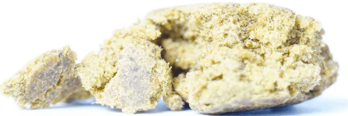 Close-up of a pale yellow, crumbly food item on a white background