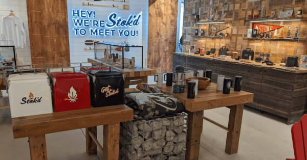 Welcome table with gift bags and a “Hey! We’re so glad to meet you!” sign in a rustic shop