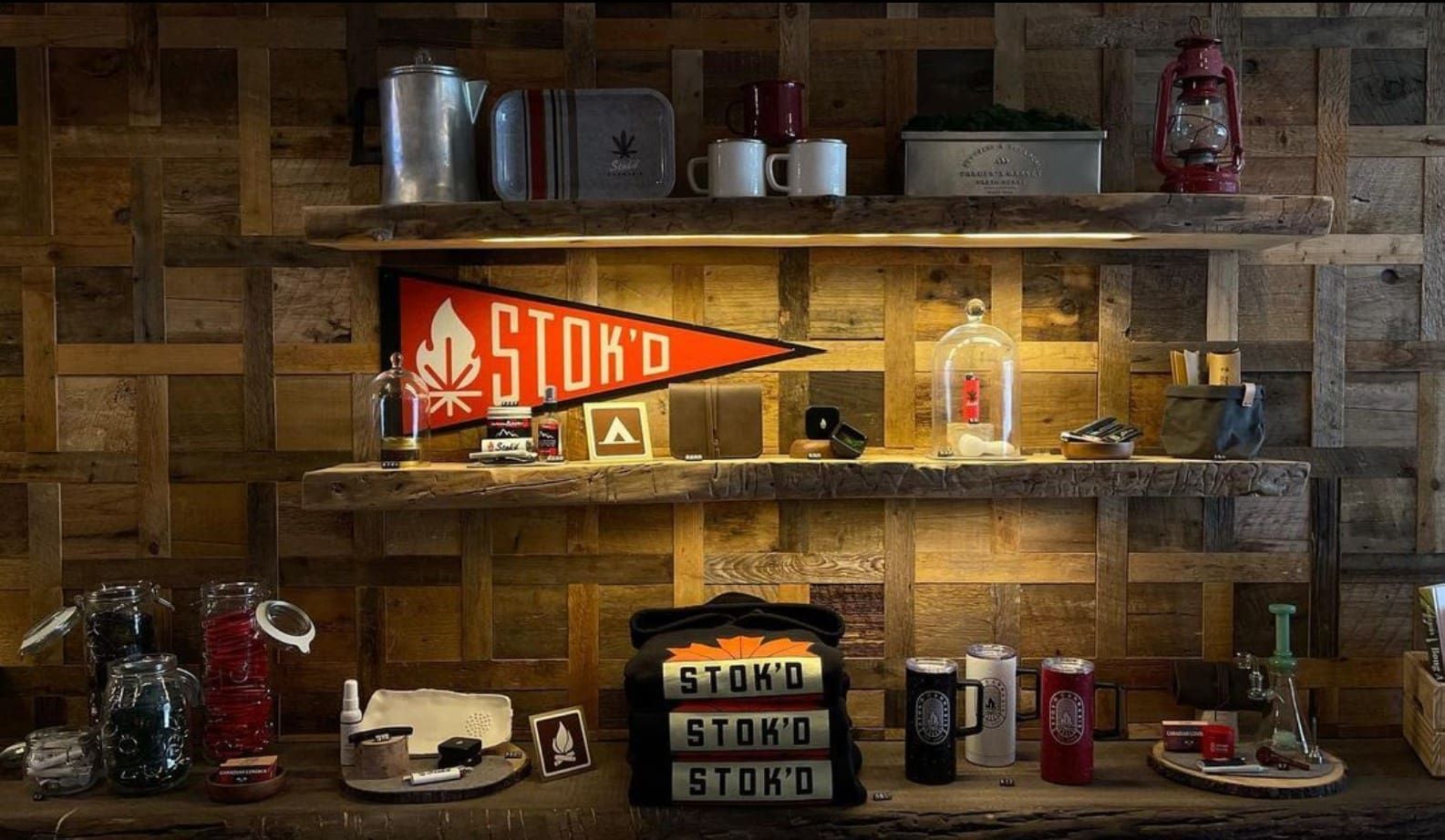 Rustic wooden shelves with vintage bottles, jars, and a red Stroh pennant in warm light