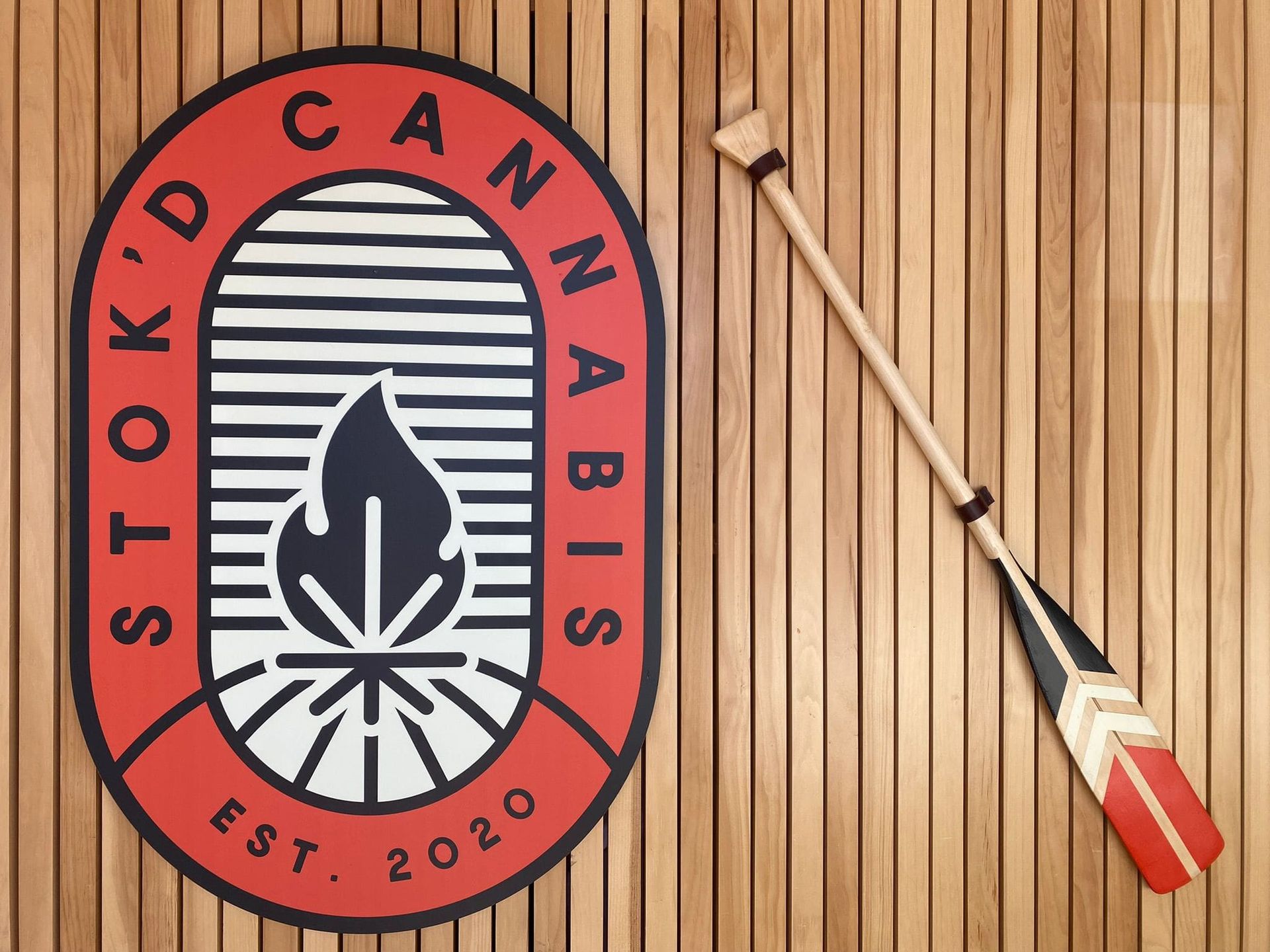 Sticker on wood with “Stock Cannabis” logo and a red-and-white cannabis spoon