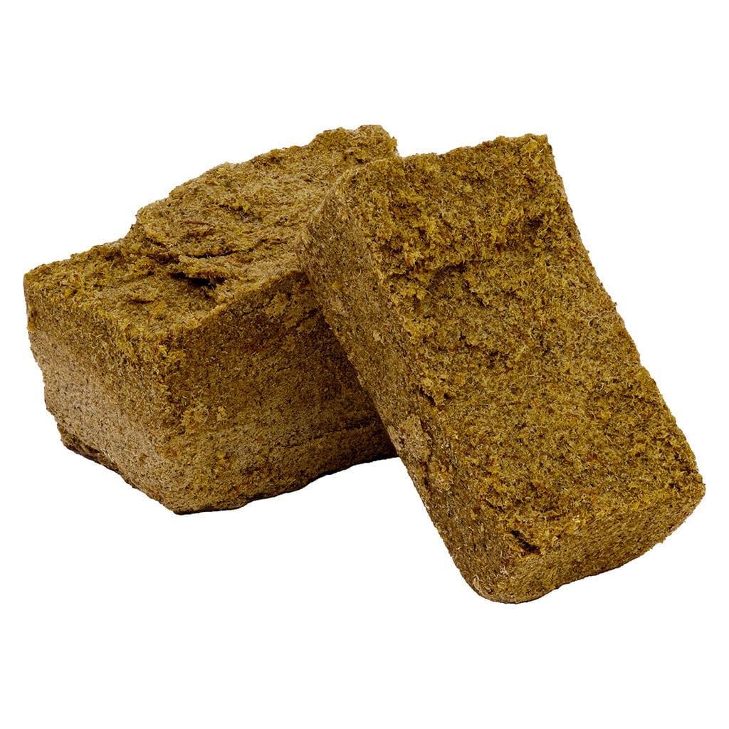 Two brown textured cannabis hash blocks on a white background