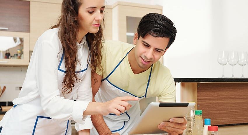 Two clinicians examining a tablet in a medical office, one pointing at the screen