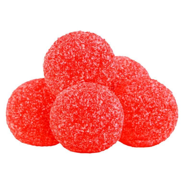 Red sugar-coated gummy candies stacked in a small pile on a white background