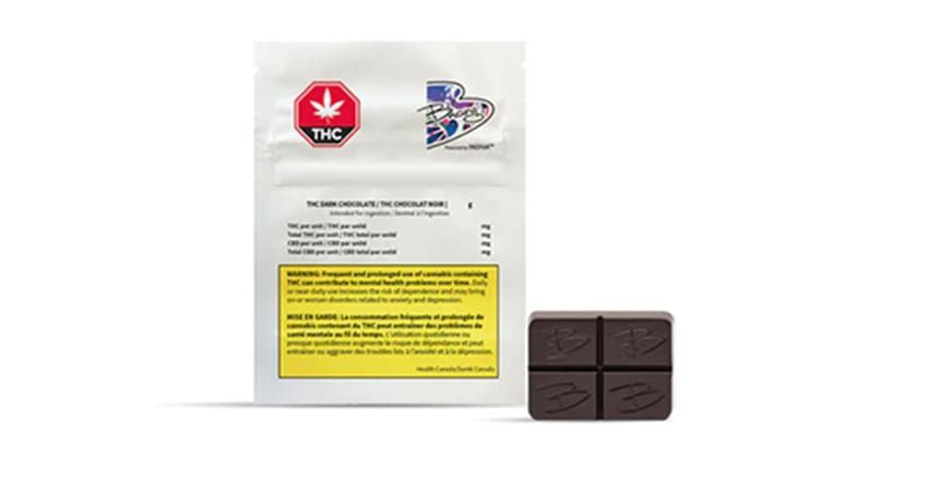 White cannabis package with red and blue logos beside four dark brown chocolate squares on a white background