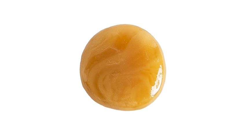 Golden amber round candy on a white background