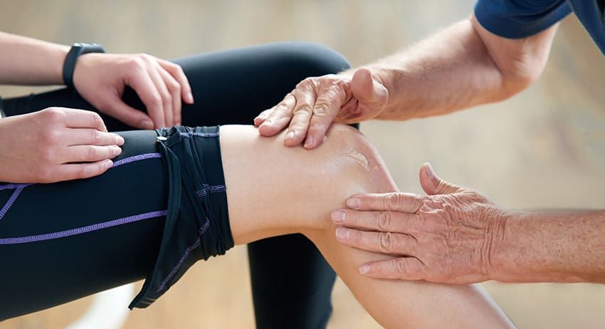 Hands rubbing a person’s knee during physical therapy or massage treatment