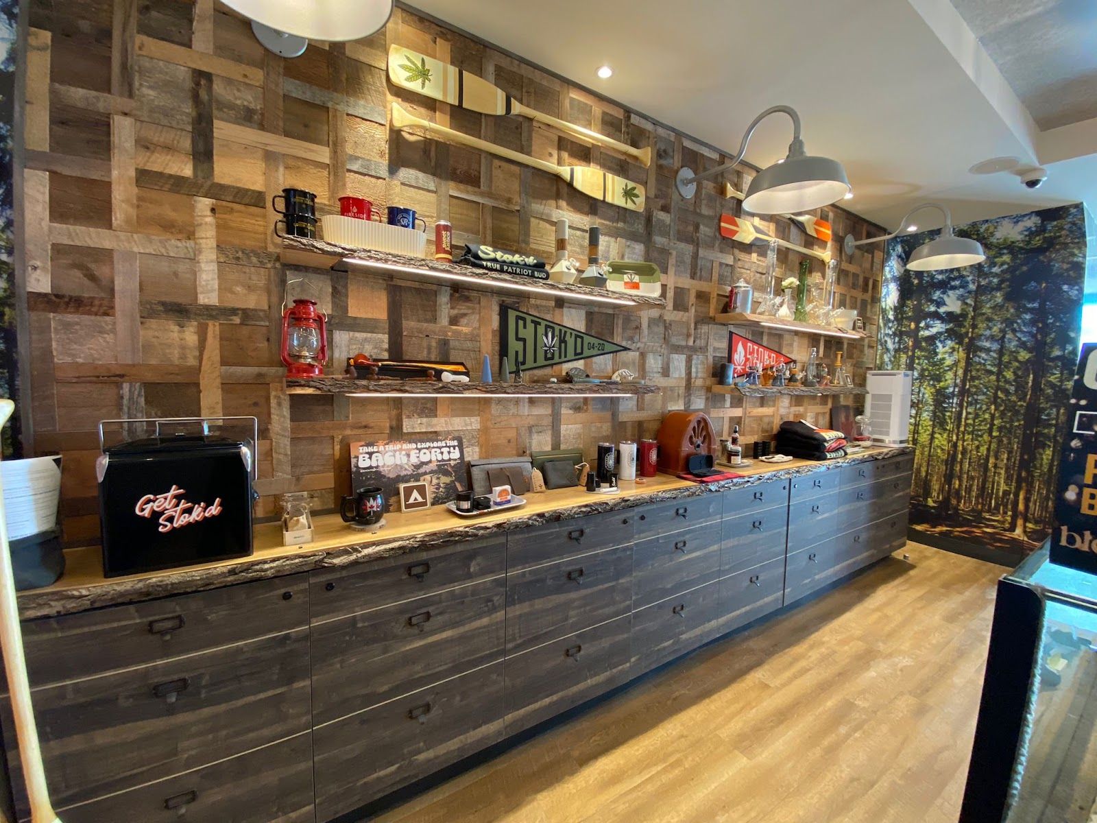 Modern café counter with shelves of jars, mugs, and decor, set against a wood-paneled wall