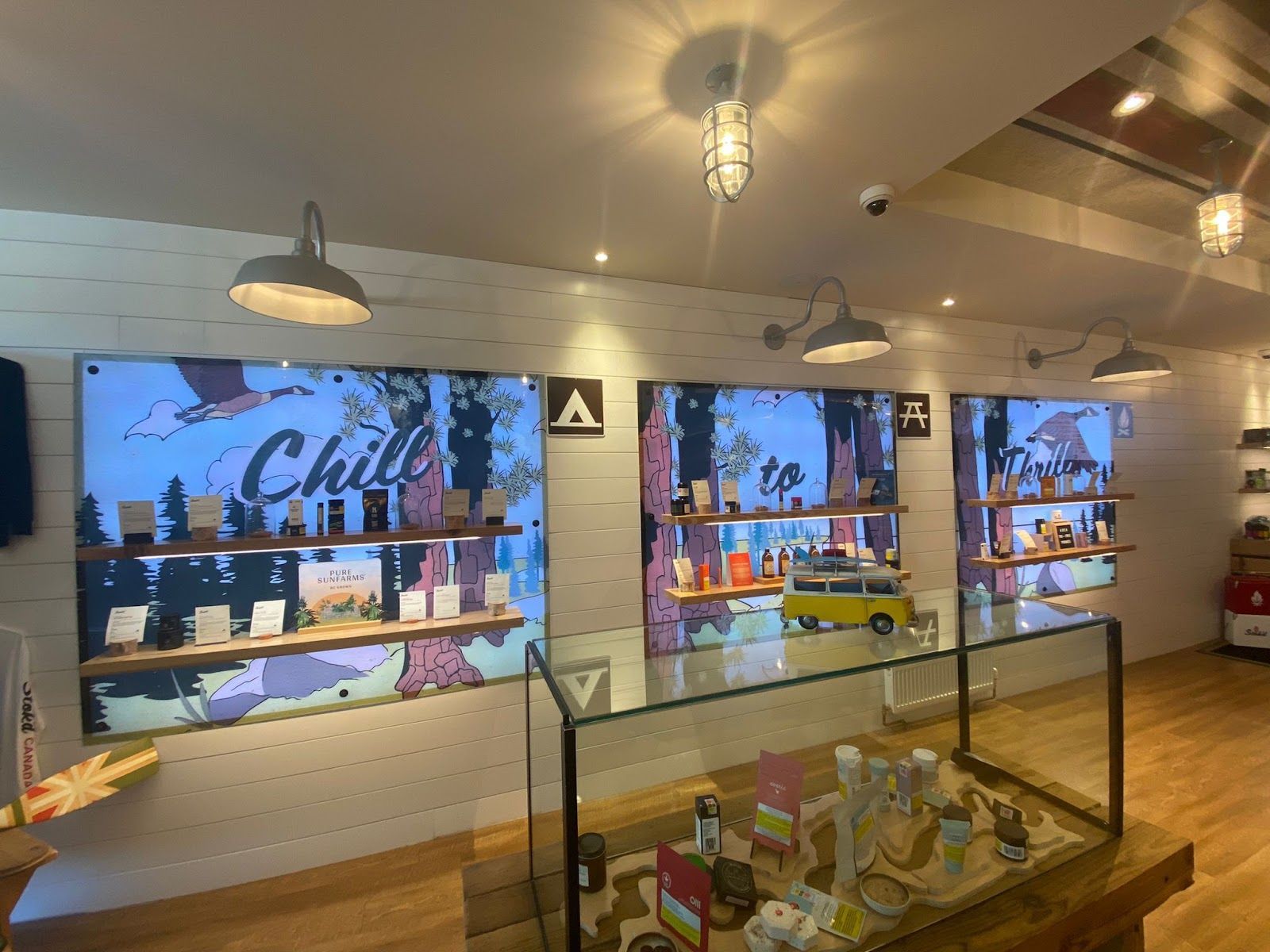 Modern cafe interior with glass display cases, wall shelves, and colorful mural artwork