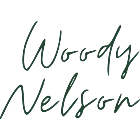 Handwritten dark green script reading “Woody Nelson” on a white background