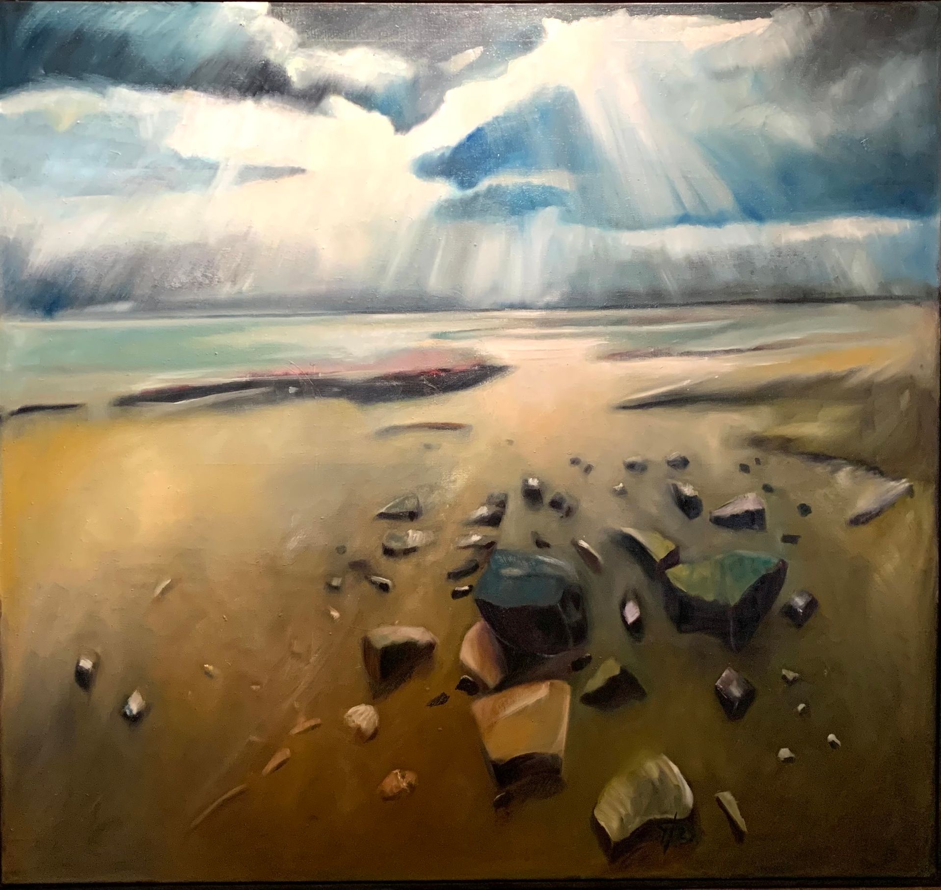 Felsige Küste im dramatischen Lichtspiel von Sonnenstrahlen und Wolken, mit verstreuten Steinen auf nassem Sand