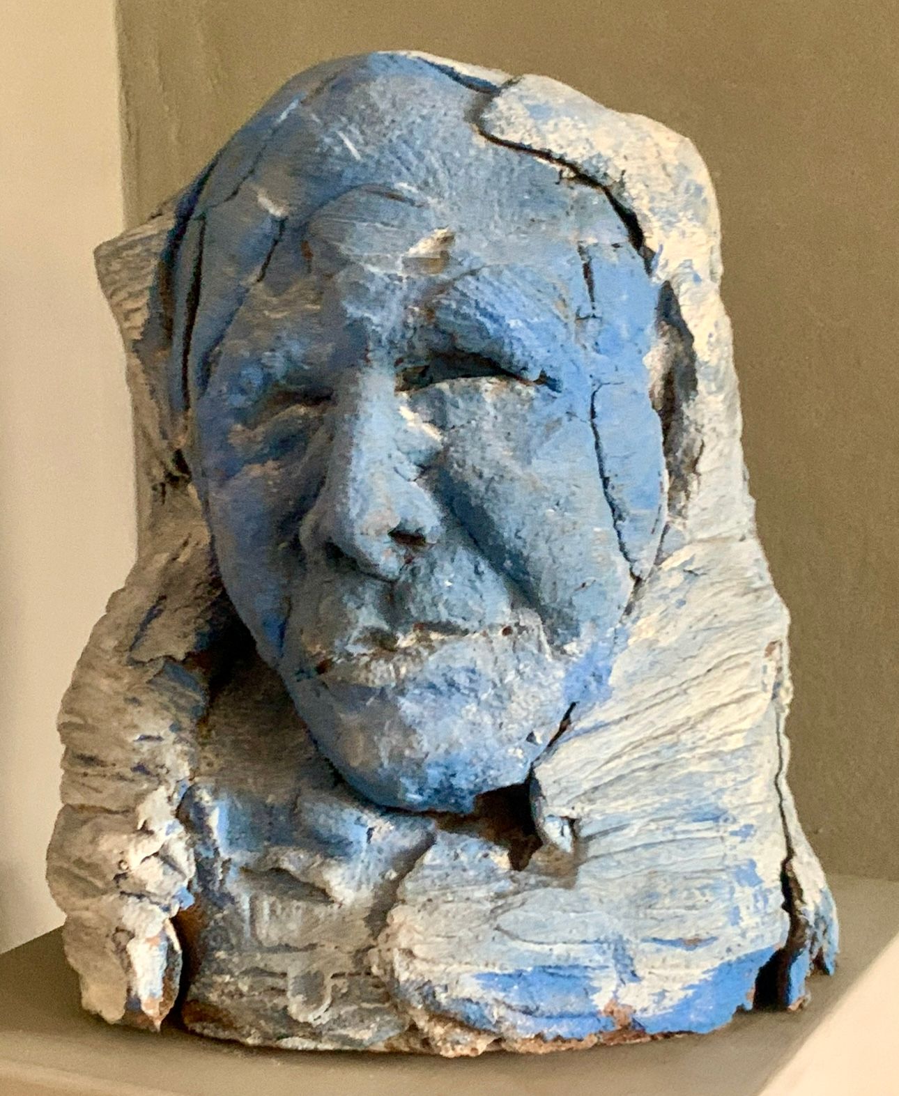 Blau-weiße, skulptierte Büste eines älteren Gesichts mit einer verwitterten, strukturierten Oberfläche
