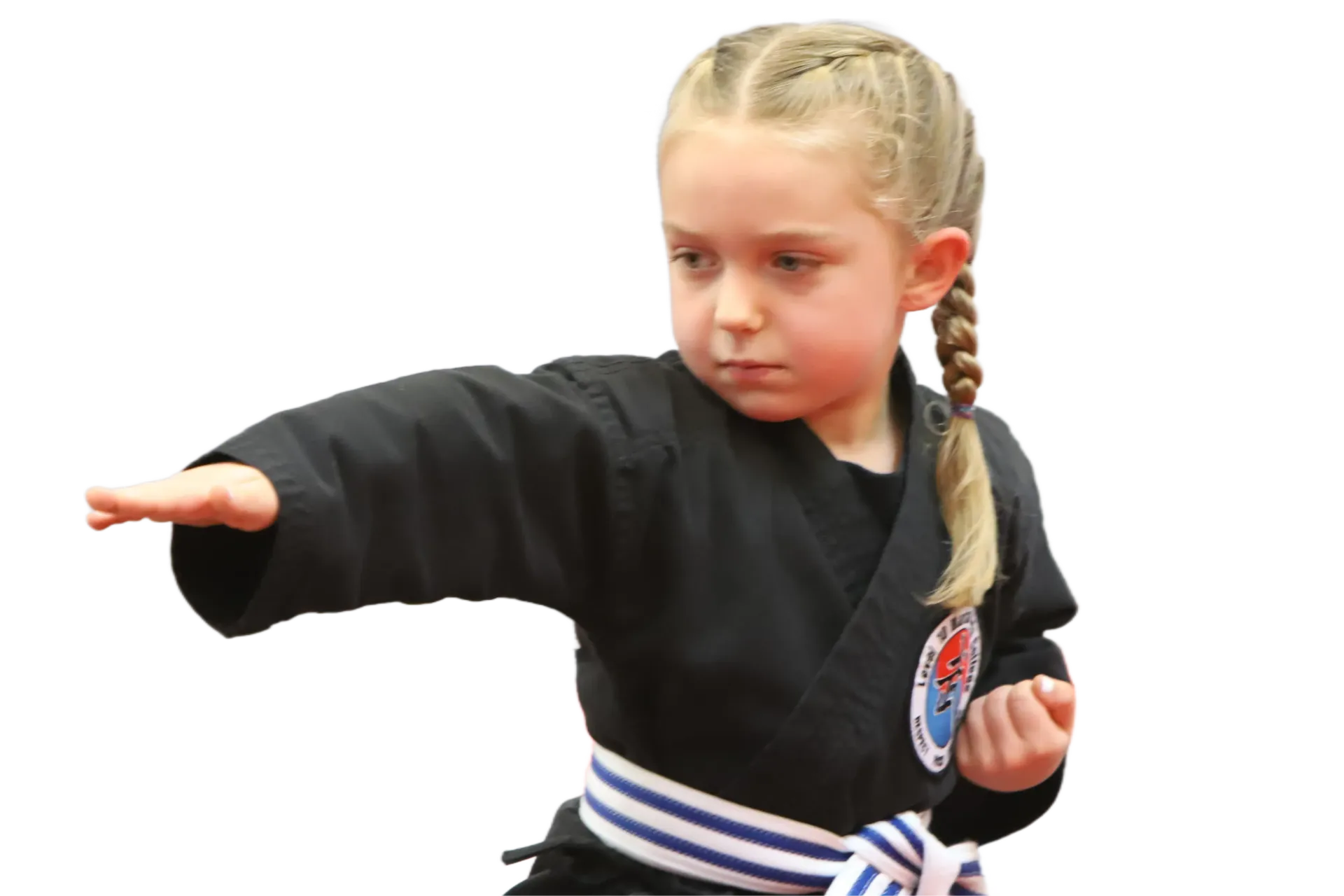 Child in a black martial arts uniform with braided hair, extending one arm in a focused pose.
