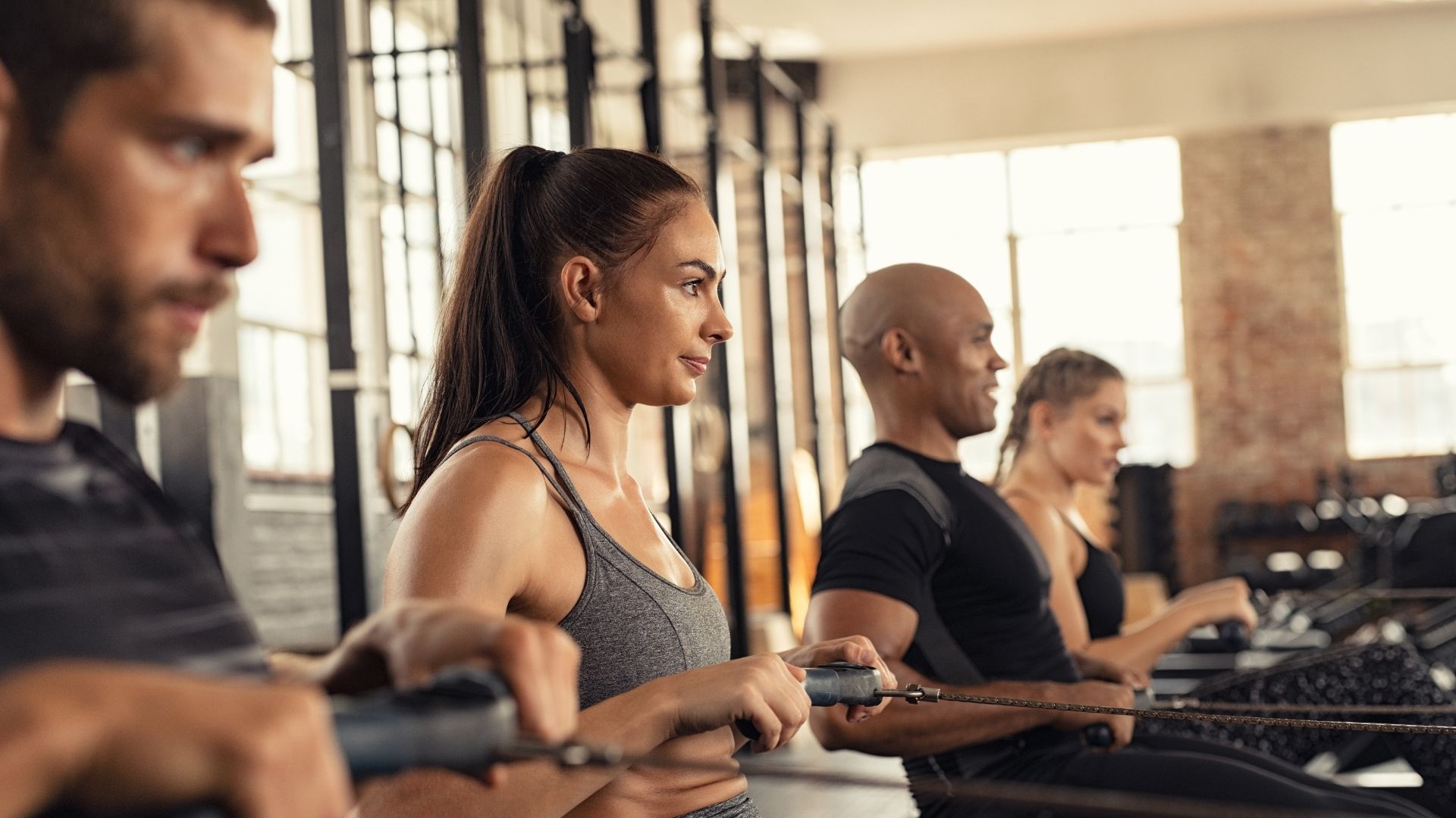 A female following a workout schedule for women in a gym with men and women