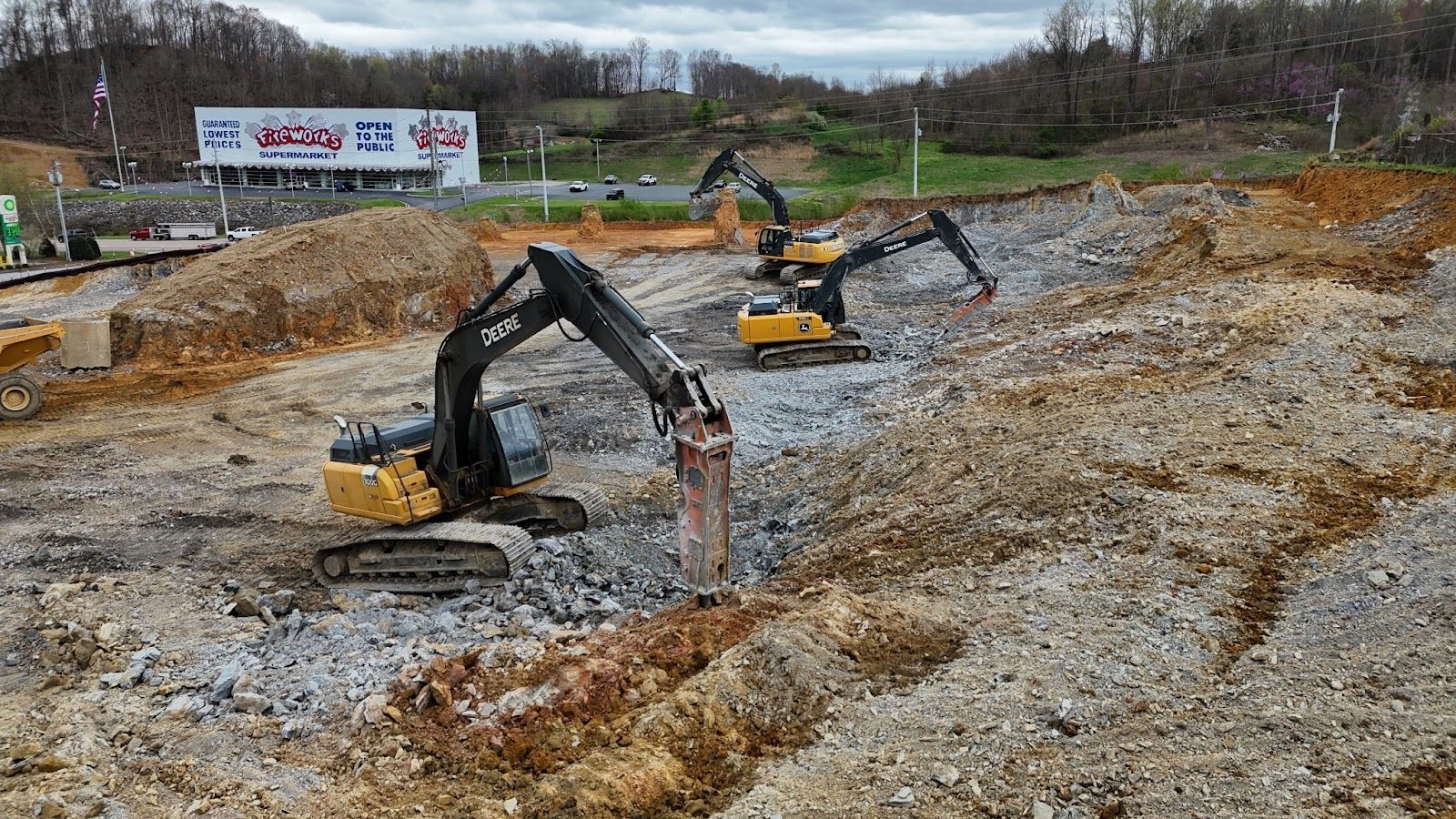 A group of excavators are working on a construction site.