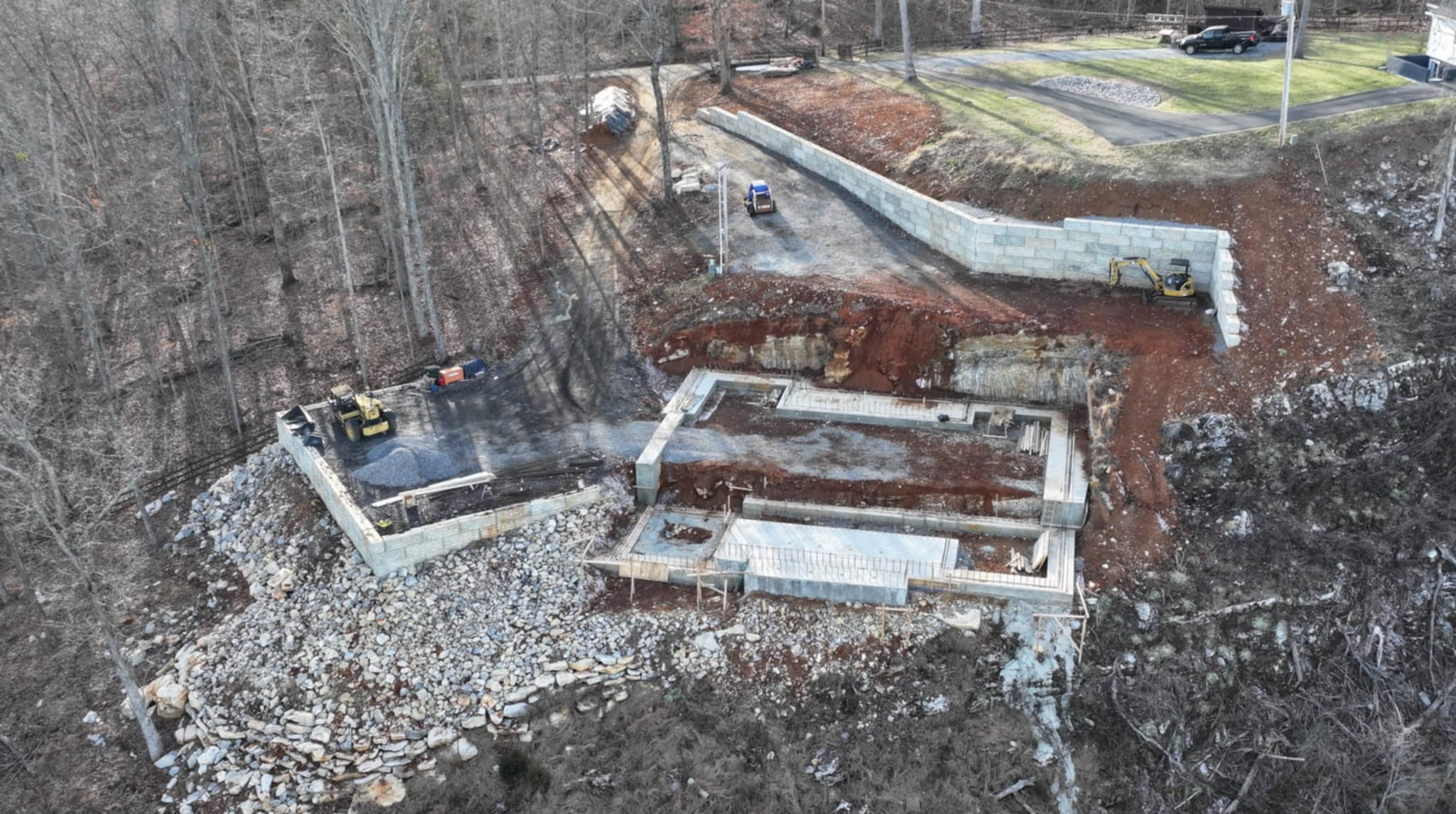 An aerial view of a house under construction in the woods.