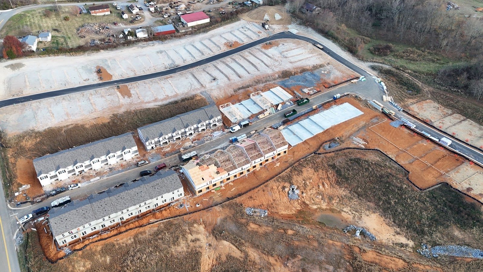 An aerial view of a building under construction in the middle of a dirt field.