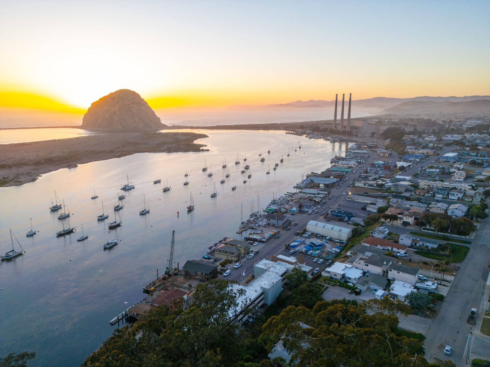 An aerial view of a city with boats in the water at sunset.