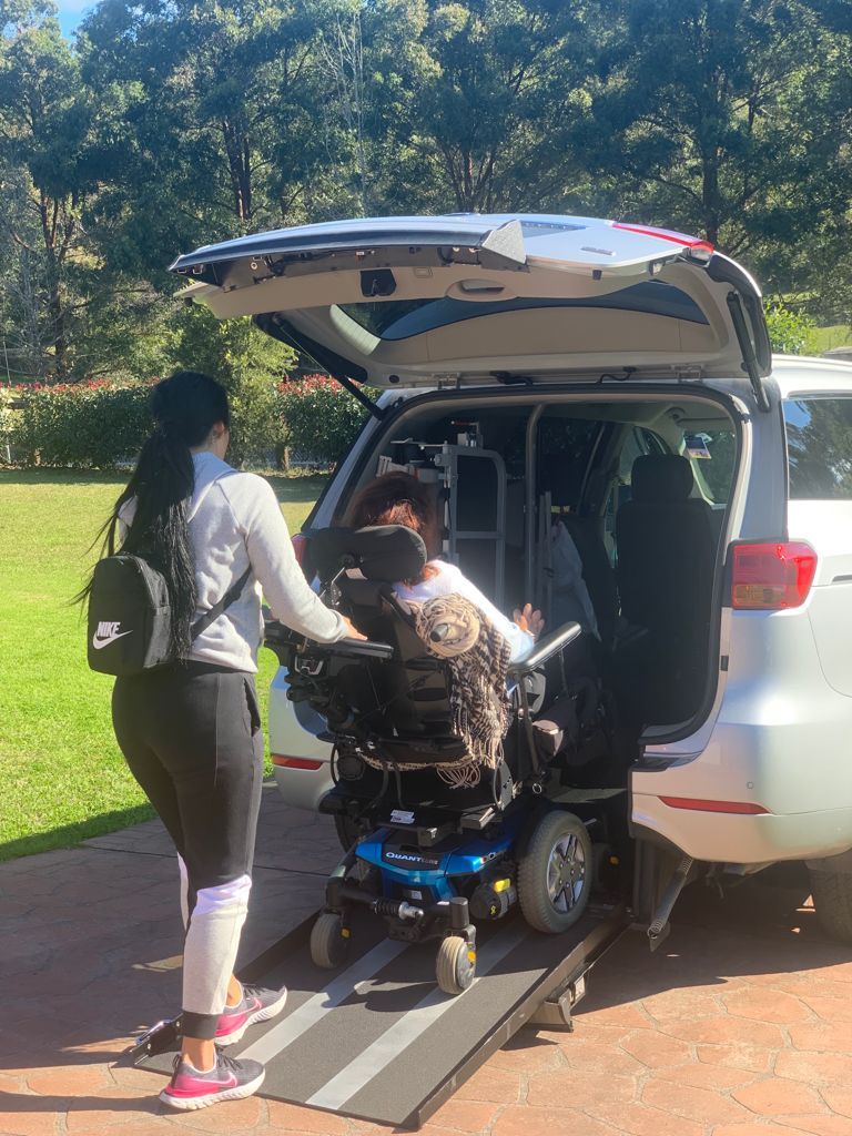 RM Care Royal Miracle Care Australia disability support carer helping woman in wheelchair into car