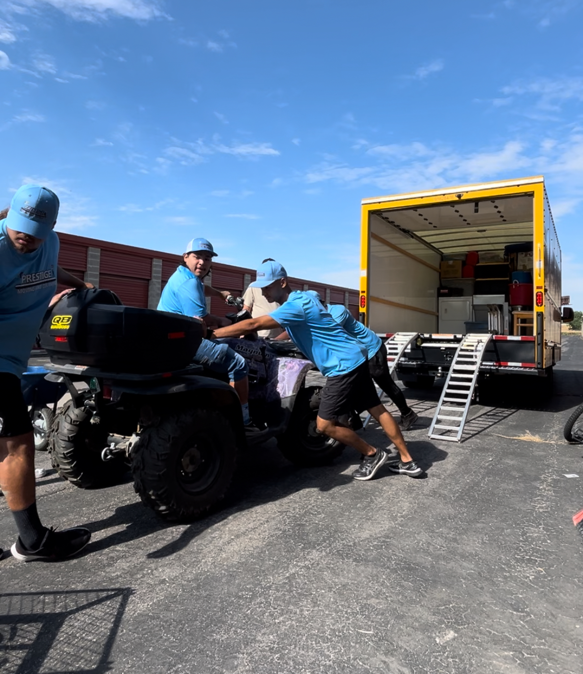 A group of men are pushing a motorcycle into a truck.