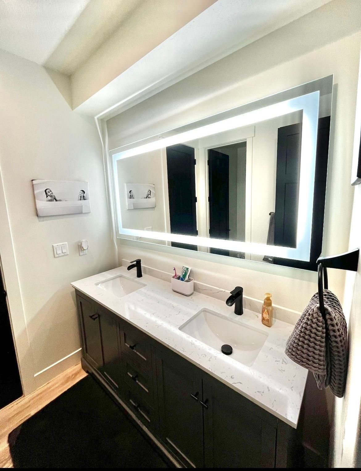 A bathroom with two sinks and a large mirror.