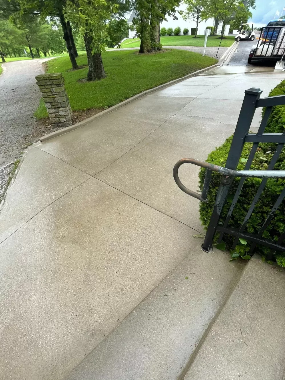 A sidewalk with stairs and a fence on the side of it.