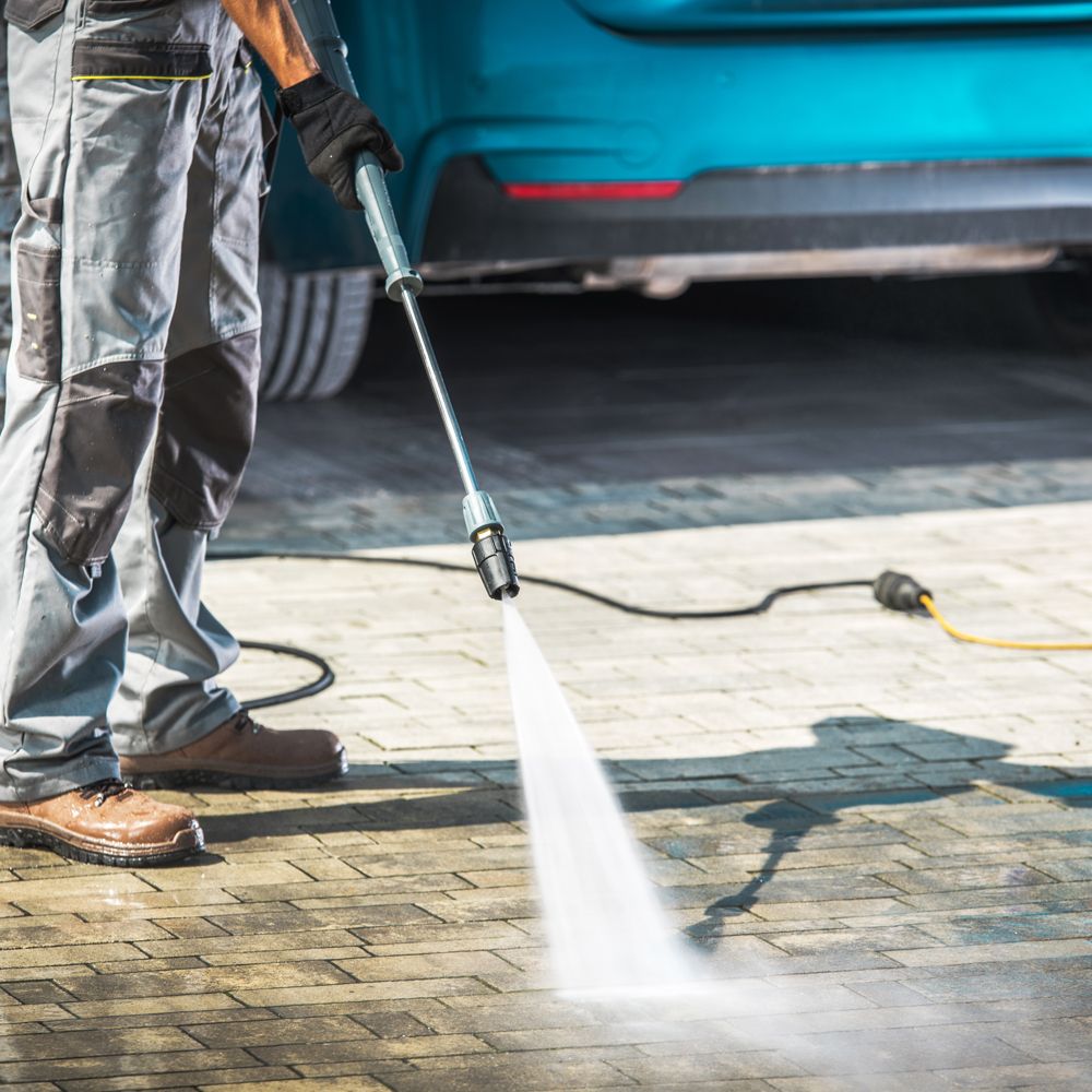 Professional Worker Cleaning a Dirty Driveway