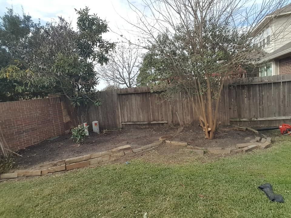 Backyard with grass, wooden fence, bare trees, and a small patio area