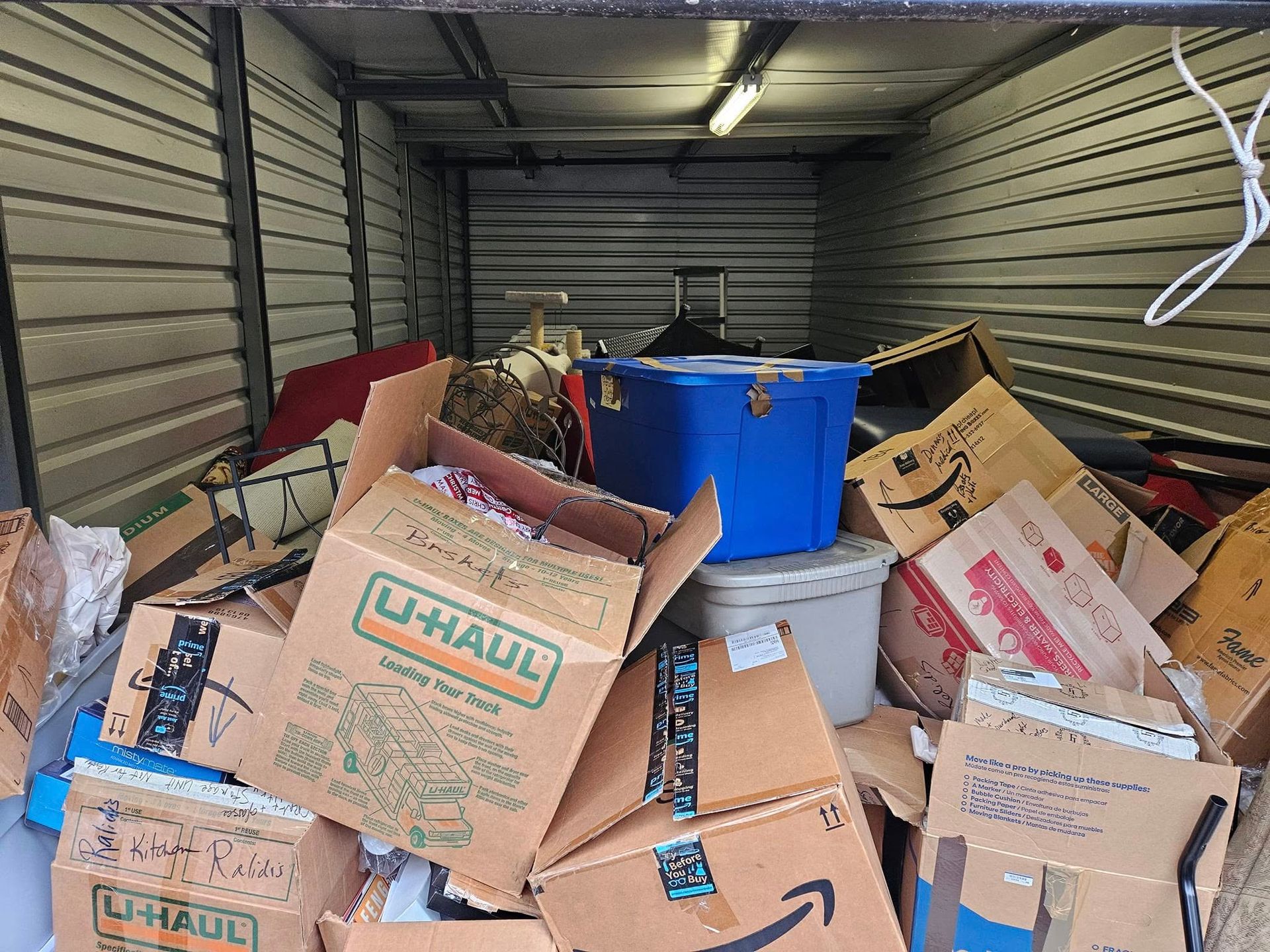 Packed moving boxes and bins inside a storage unit