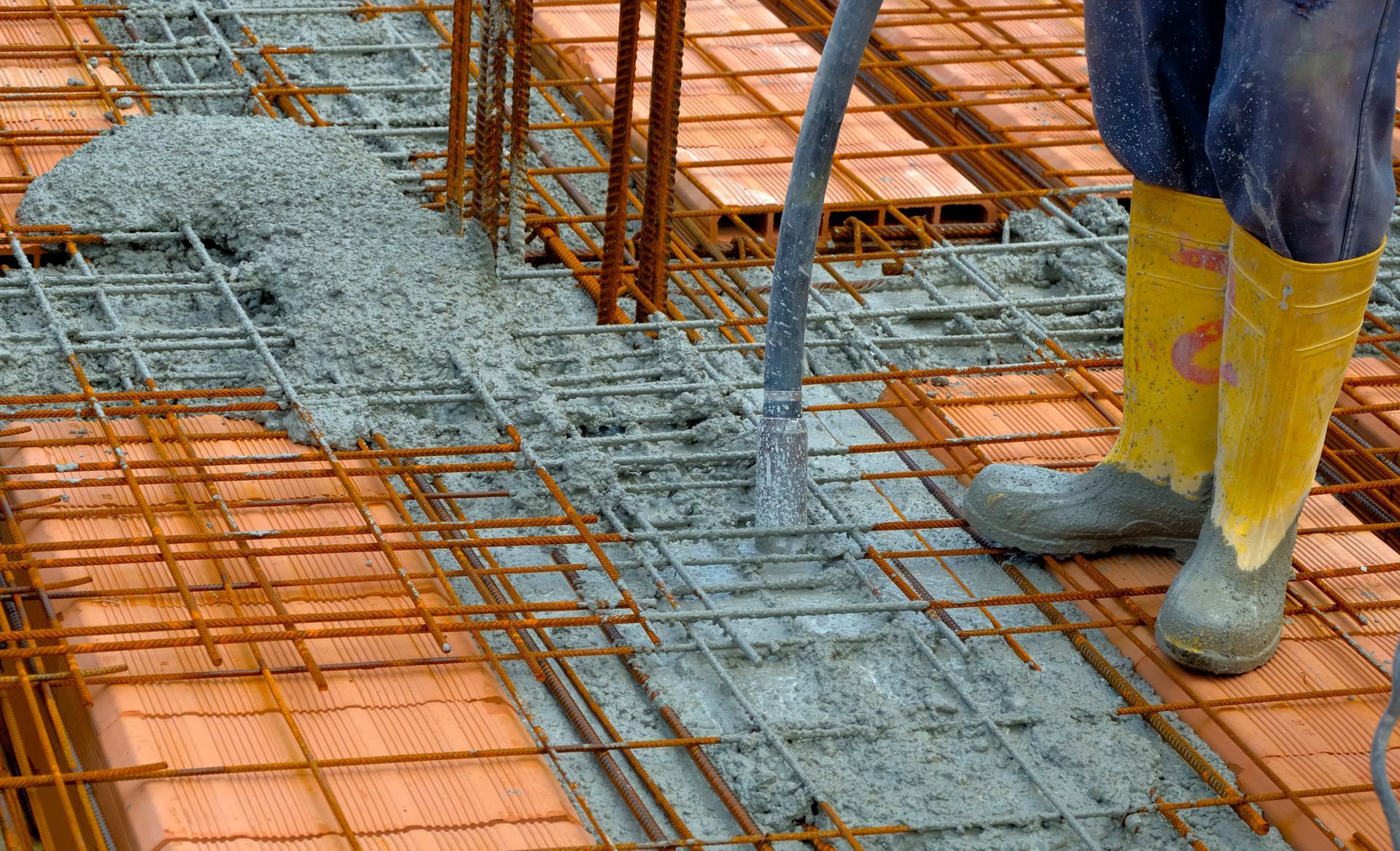 Construction worker doing a Concrete Contractor Services compacting liquid cement