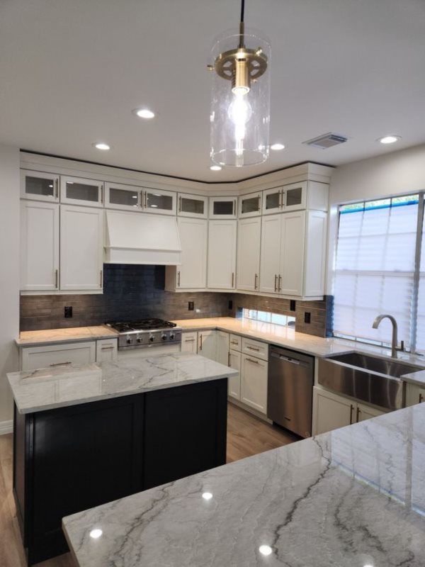 A kitchen with white cabinets and stainless steel appliances