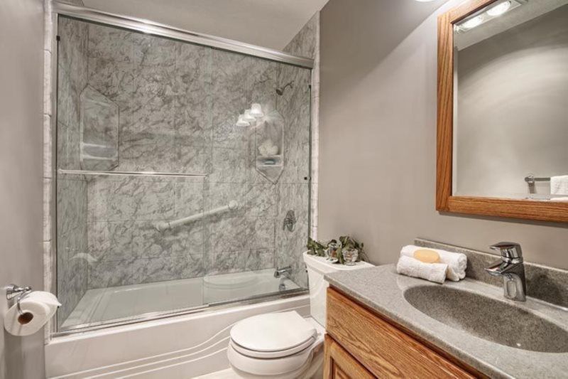 A bathroom with a toilet , sink , and shower.