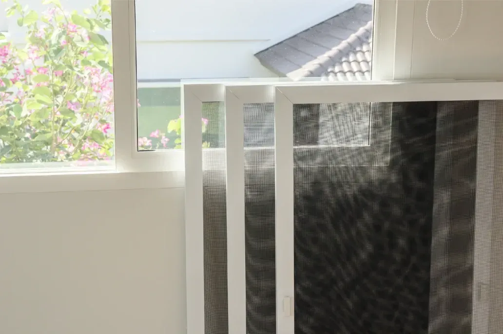 Ein weißer Zaun steht neben einem Fenster in einem Zimmer.