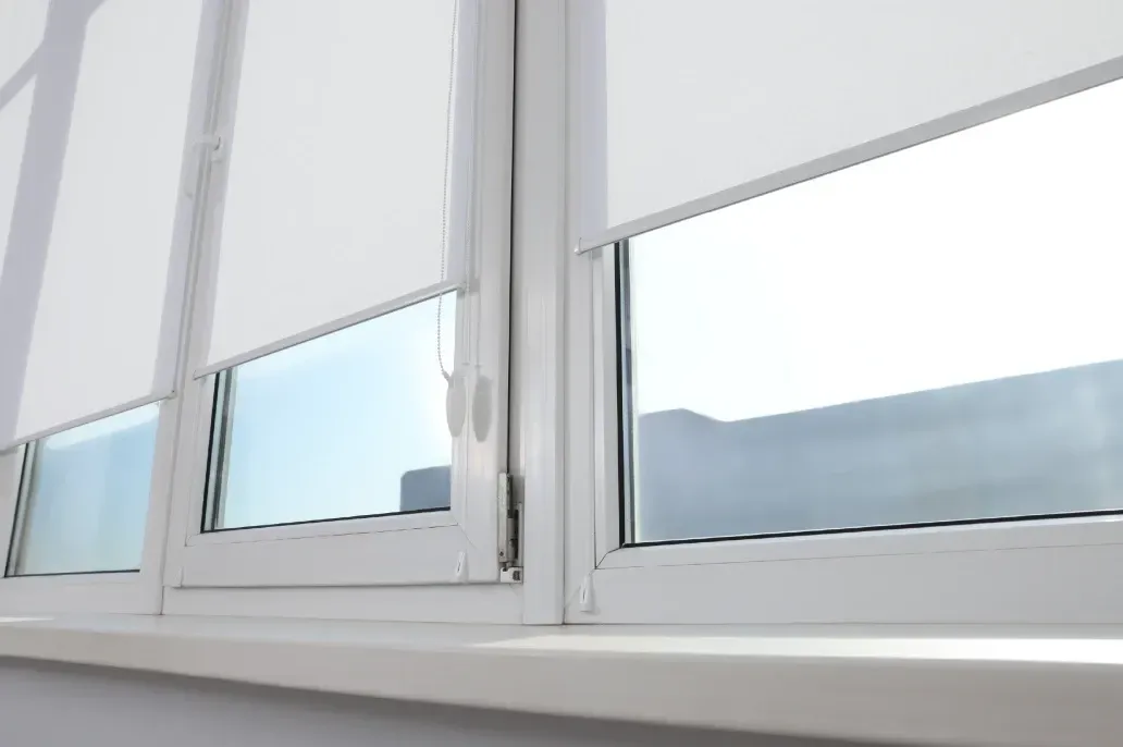 Eine Nahaufnahme eines Fensters mit weißen Jalousien.