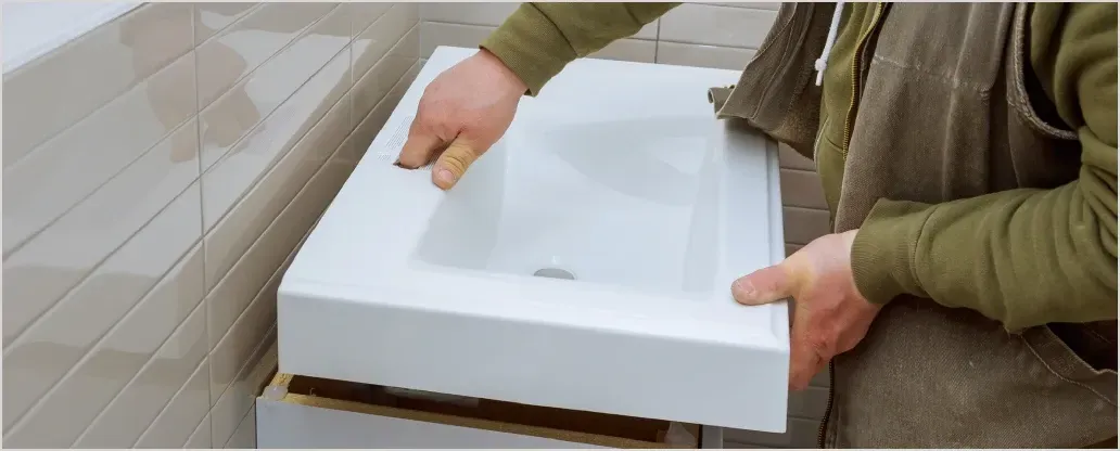 Ein Mann installiert ein Waschbecken in einem Badezimmer.