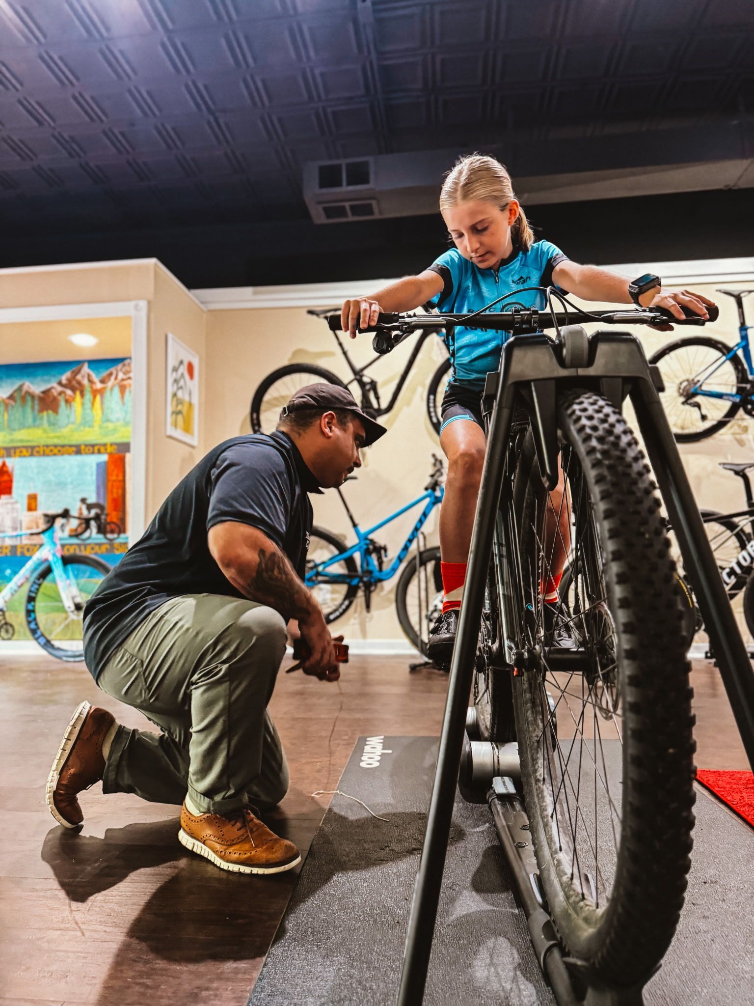 Bike mechanic adjusts a child’s bicycle in a bike shop.