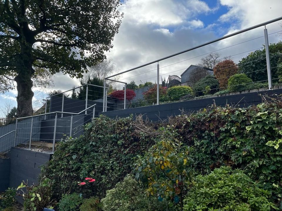 Raised composite deck with a stainless steel wire balustrade on a sloping garden in Totley, Sheffield