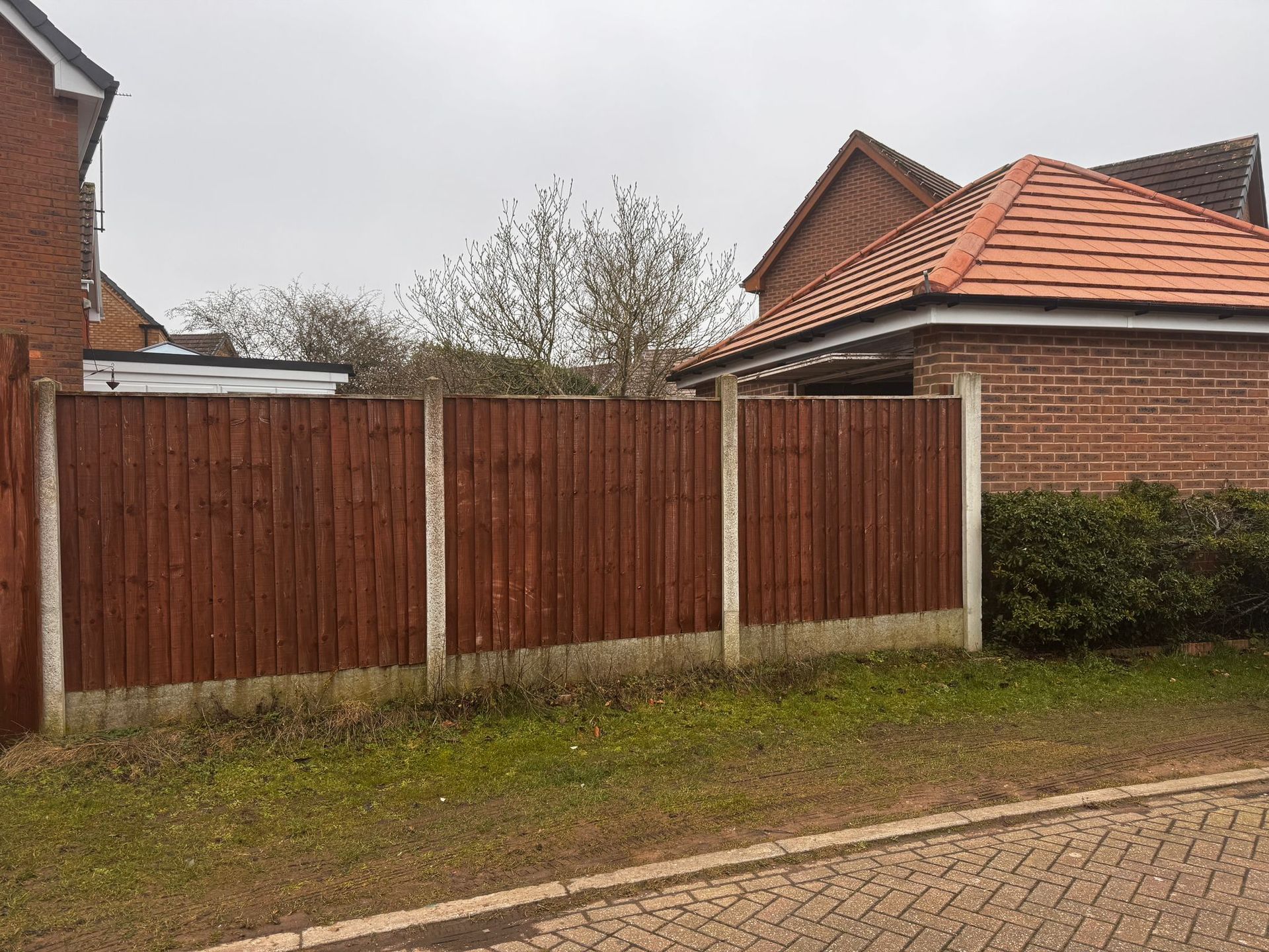 Dark stained closeboard fence panels between concrete posts and gravel boards at a modern house in Crosspool, Sheffield