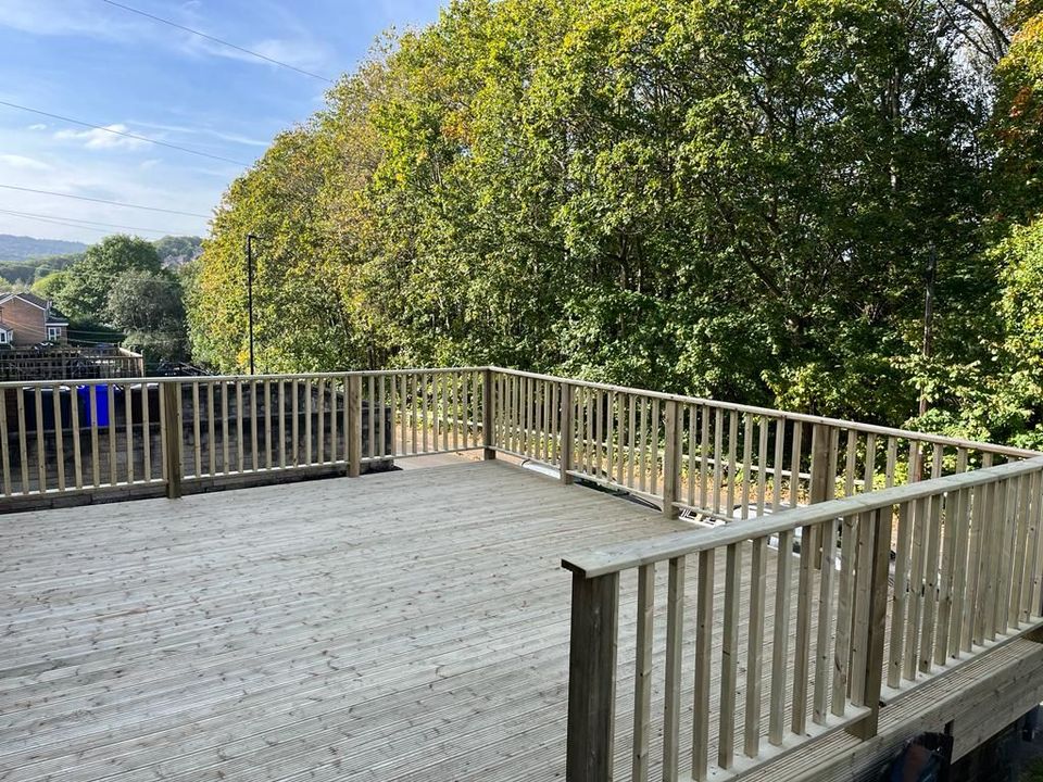 Raised timber deck with a timber spindle balustrade on a sloping garden in Sheffield